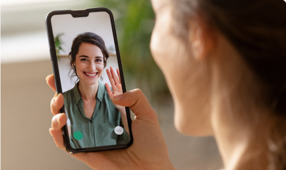 A therapist on a video call shown on a phone screen